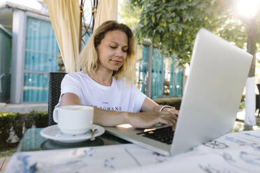 Smiling freelancer working on laptop - SIF00214