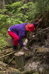 Frau untersucht die Wurzeln eines Baumes im Wald - VPIF06612