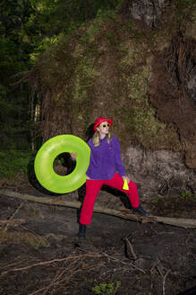 Woman wearing sunglasses holding inflatable ring - VPIF06624