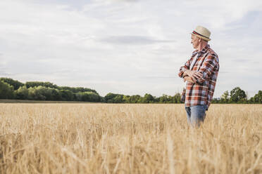 Landwirt mit verschränkten Armen auf einem Bauernhof - UUF26682