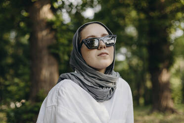 Junge Frau mit Kopftuch und Sonnenbrille im Park - KASF00002