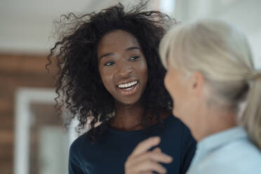 Smiling businesswoman talking with colleague in office - KNSF09383