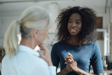 Businesswoman talking with colleague in office - KNSF09395