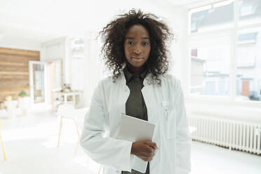 Female doctor with curly hair holding tablet PC - KNSF09407