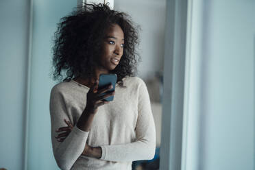 Young woman holding smart phone - KNSF09446