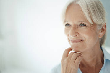 Happy senior businesswoman against white background - KNSF09548