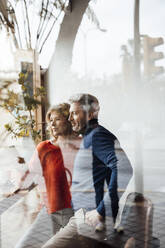 Couple together in cafe seen through glass - JOSEF10851