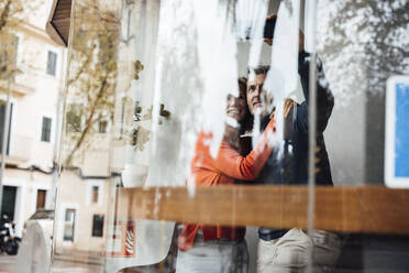 Man with woman taking selfie through smart phone in cafe - JOSEF10852