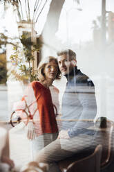 Man with woman in cafe seen through glass - JOSEF10854