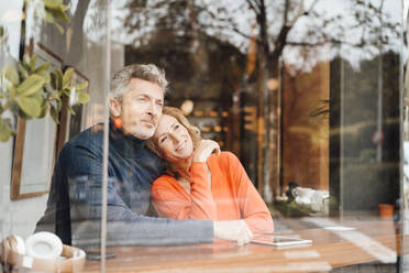 Lächelnde Frau mit Mann in Café sitzend durch Glas gesehen - JOSEF10892