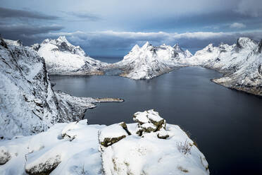 Luftaufnahme der Reine-Bucht und der schneebedeckten Berge im Winter, Nordland, Lofoten, Norwegen, Skandinavien, Europa - RHPLF22169