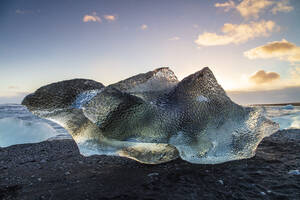 Eisberg vom schmelzenden Gletscher am schwarzen Sandstrand in der Nähe der Gletscherlagune Jokulsarlon, Vatnajokull-Nationalpark, Island, Polarregionen - RHPLF22182