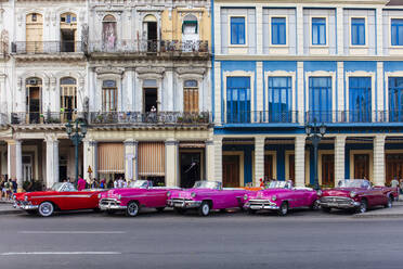 Red and pink vintage American car taxis on street in Havana, Cuba, West Indies, Central America - RHPLF22237