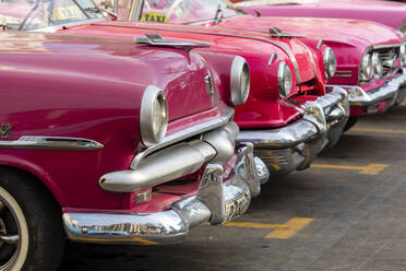 Rote und rosafarbene amerikanische Oldtimer-Taxis auf der Straße in Havanna, Kuba, Westindien, Mittelamerika - RHPLF22238