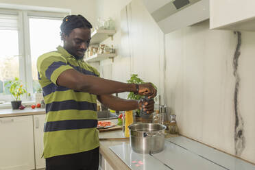Junger Mann bereitet Essen in der Küche zu - OSF00301