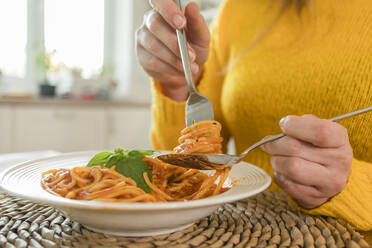 Hände einer Frau halten Gabel mit Spaghetti zu Hause - OSF00309