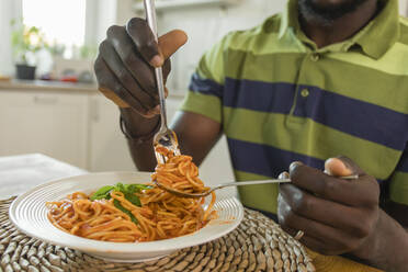 Hands of man holding fork with spaghetti at home - OSF00310