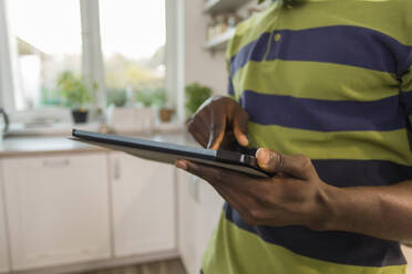 Hands of man using tablet PC in kitchen at home - OSF00313