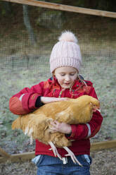 Girl petting chicken - FOLF11509