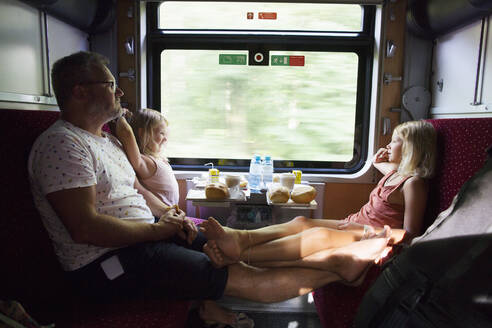 Familie sitzt am Fenster im Zug - FOLF11532
