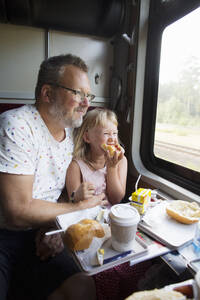 Vater und Tochter beim Frühstück im Zug - FOLF11533