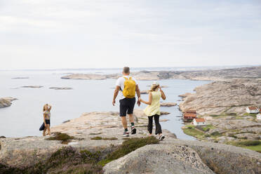 Familie spaziert auf Felsen an der Küste - FOLF11557