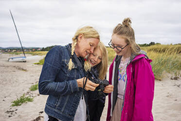 Woman showing daughters photograph on camera - FOLF11578