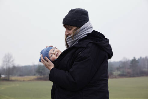 Frau trägt Tochter in Babytrage - FOLF11607