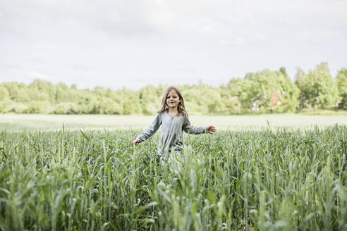 Mädchen in grauem Kleid geht im Feld - FOLF11632