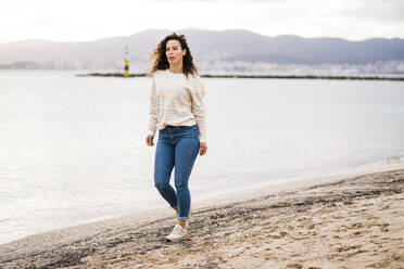 Mature woman walking on beach at weekend - JOSEF11003