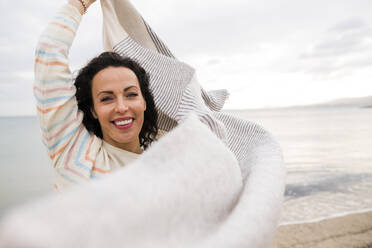 Smiling mature woman with scarf at beach - JOSEF11014