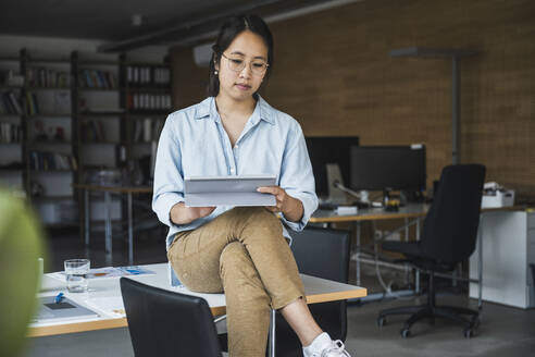 Geschäftsfrau mit Tablet-PC auf dem Schreibtisch im Büro - UUF26781