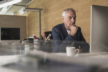 Geschäftsmann arbeitet am Computer am Schreibtisch im Büro - UUF26808