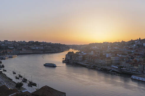 Portugal, Bezirk Porto, Vila Nova de Gaia, Fluss Douro und die umliegende Stadt bei Sonnenuntergang - MTBF01252