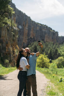 Glücklicher Mann macht Selfie mit Frau durch Smartphone in Aragon, Spanien - DAMF01019