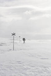 Junge Frau beim Wandern im Schnee - FOLF11788