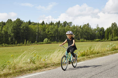 Girl riding bicycle on road - FOLF11814