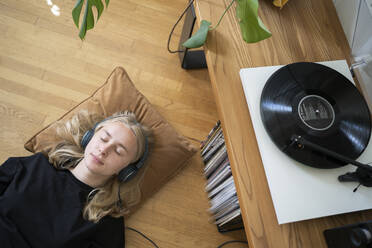 Teenage girl listening to music on record player - FOLF11849