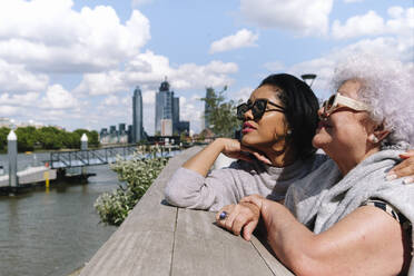 Mother and daughter standing at Battersea Bridge on sunny day - ASGF02496