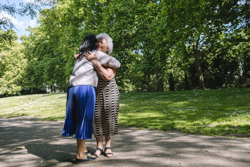 Mutter, die ihre Tochter im Park umarmt - ASGF02501