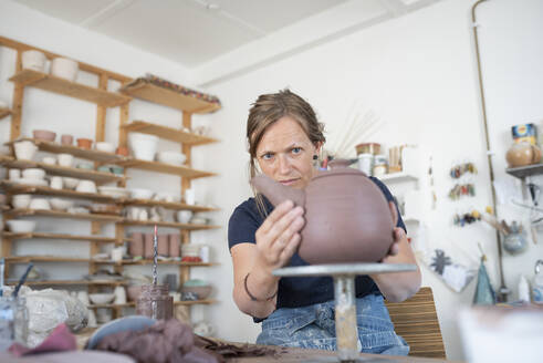 Potter making teapot in workshop - FOLF11862