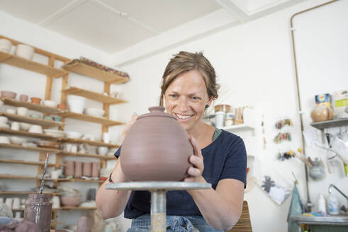 Potter making teapot in workshop - FOLF11863
