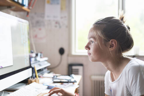 Teenage girl doing homework at computer - FOLF11878