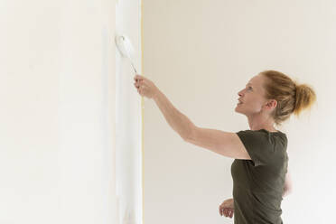 Frau malt Wand in Haus - FOLF11882