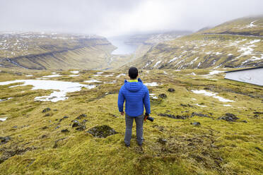 Male hiker overlooking Kaldbaksfjordur fjord - WPEF06079