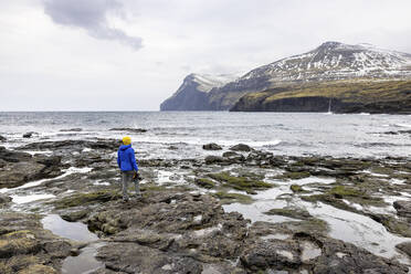 Faroe Islands, Eysturoy, Eidi, Male hiker admiring coastal landscape - WPEF06083