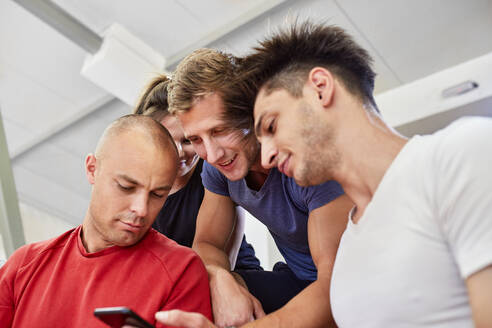 Freunde teilen sich ein Smartphone im Stadion - ZEDF04695