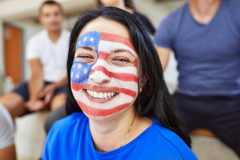 Fröhliche Frau mit amerikanischer Flagge im Gesicht - ZEDF04698