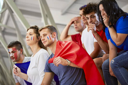 Neugierige Fans mit französischer Flagge beobachten ein Sportereignis im Stadion - ZEDF04713