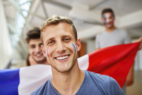 Junger Mann mit französischer Flagge im Gesicht - ZEDF04720